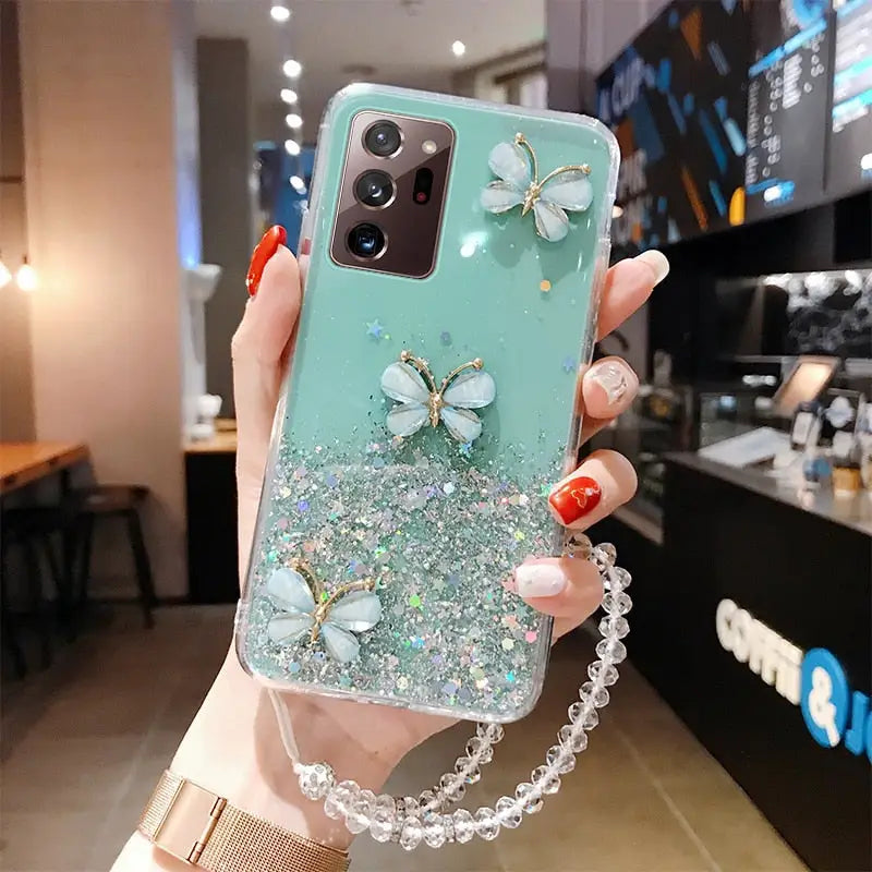 a woman holding a phone case with a green glitter phone cover