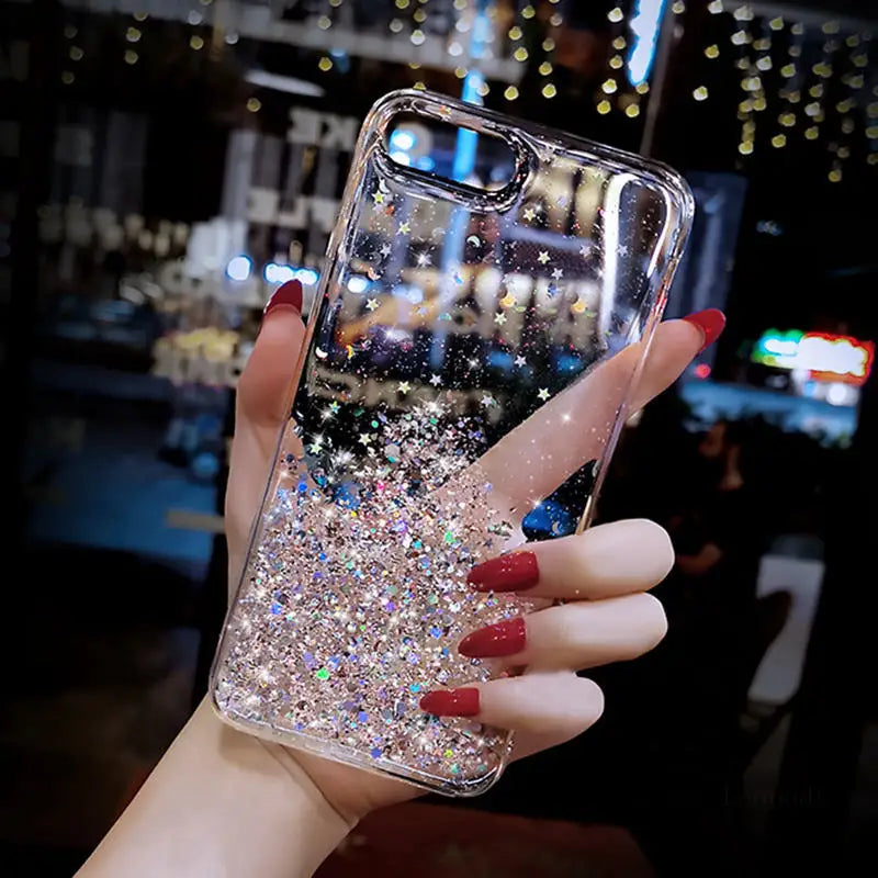 a woman holding a phone case with glitter