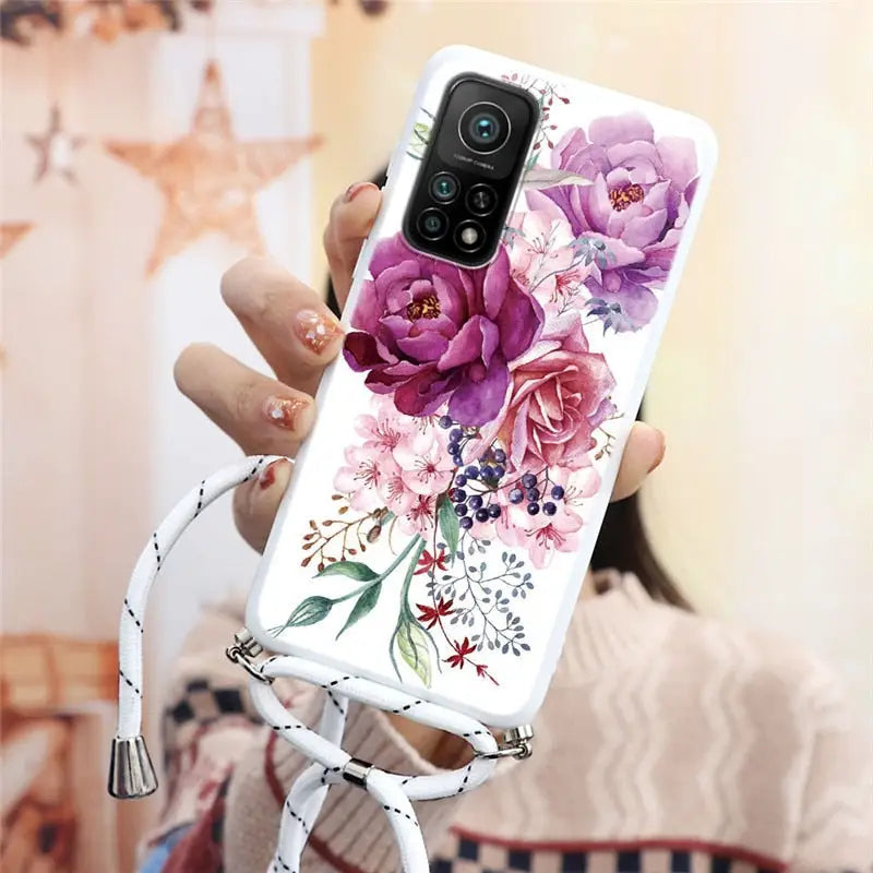 a woman holding a phone case with flowers on it