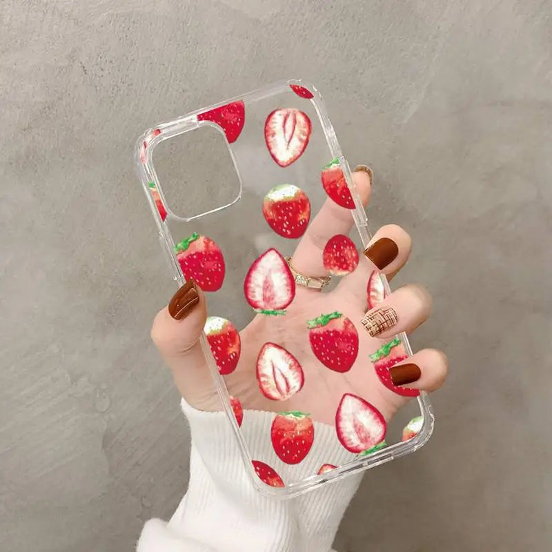 a woman holding a phone case with strawberries on it