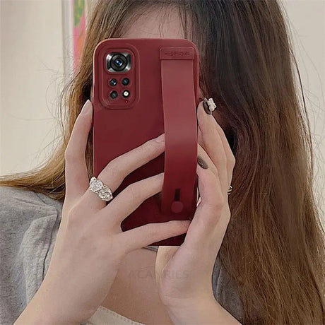 a woman holding a red phone case