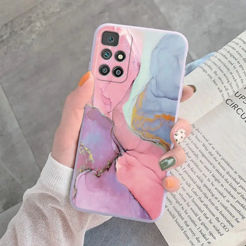 a woman holding a phone case with a painting on it