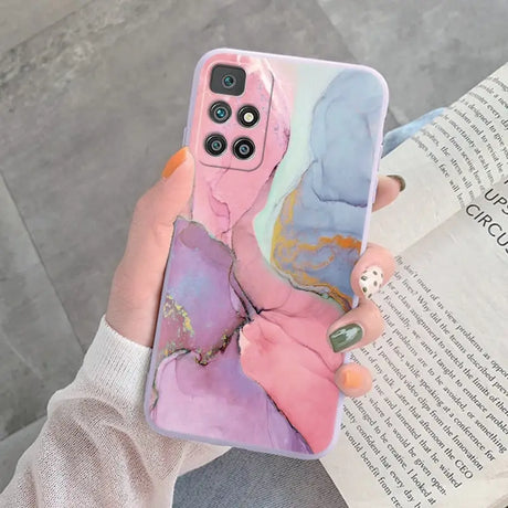 a woman holding a phone case with a painting on it