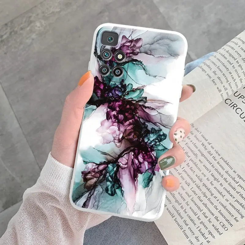 a woman holding a phone case with a purple flower on it