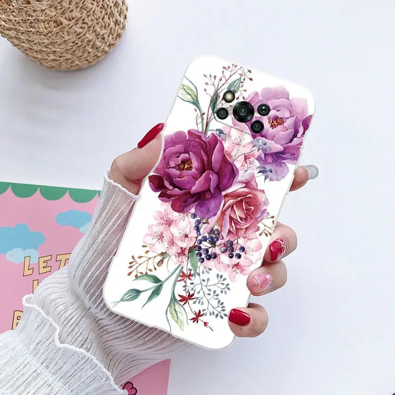 a woman holding a phone case with flowers on it