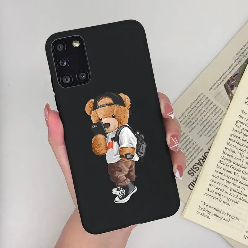a woman holding a phone case with a teddy bear