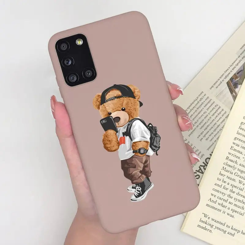 a woman holding a phone case with a teddy bear