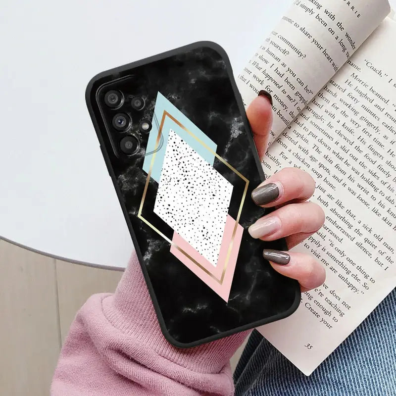 a woman holding a phone case with a geometric design