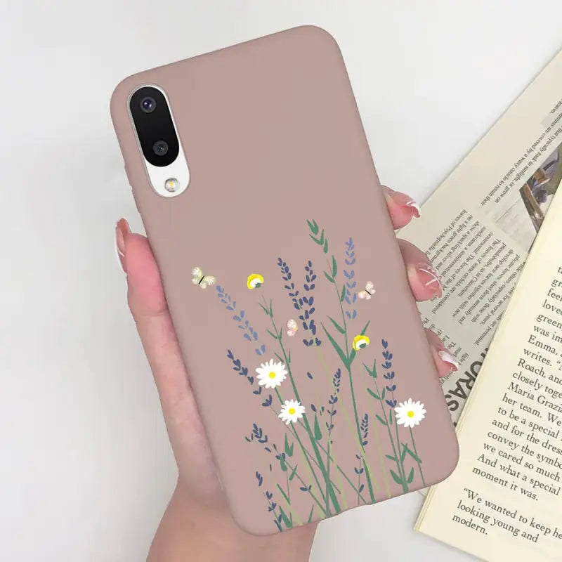 a woman holding a phone case with flowers on it
