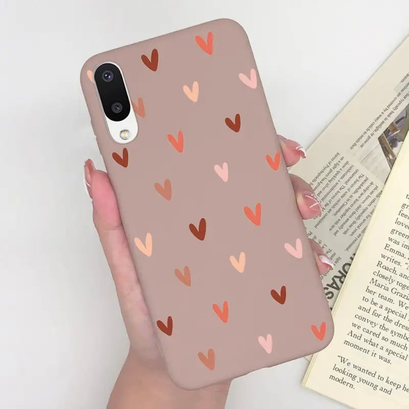 a woman holding a phone case with hearts on it