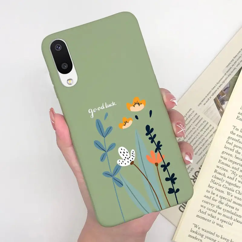 a woman holding a phone case with flowers on it