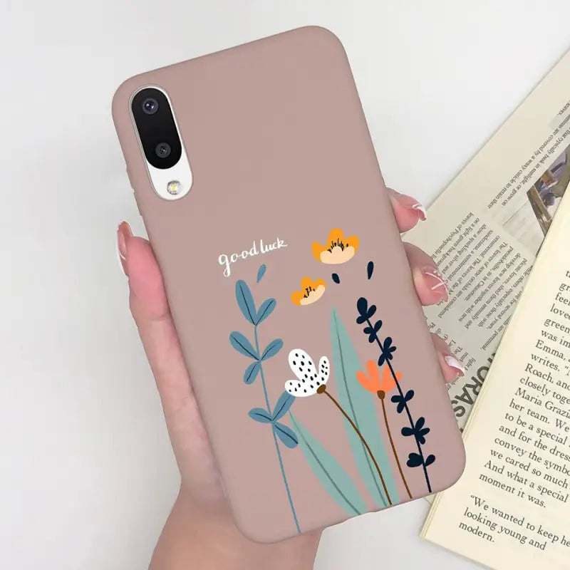 a woman holding a phone case with flowers on it