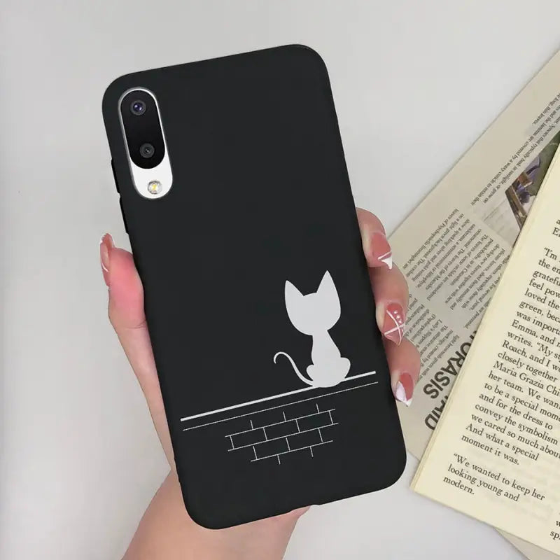 a woman holding a phone case with a cat on it