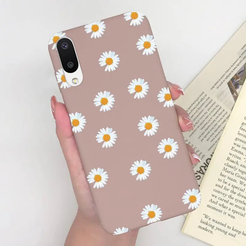 someone holding a phone case with a daisy pattern on it
