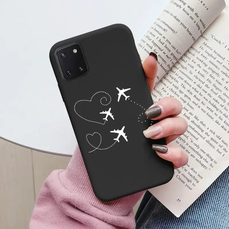 a woman holding a book and a phone case