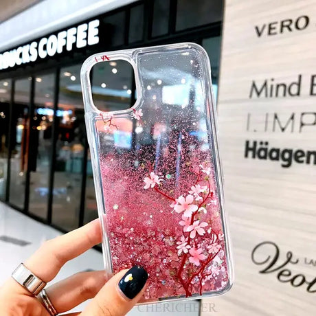 a woman holding a phone case with pink flowers on it