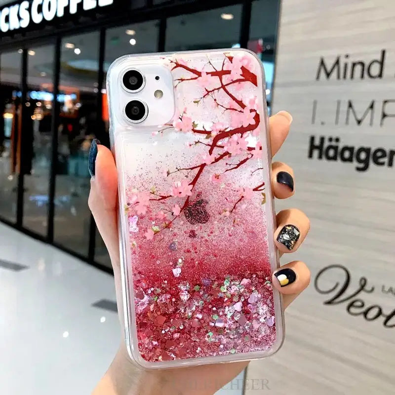 a woman holding a phone case with pink glitter