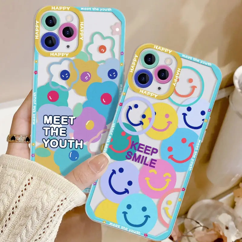 a woman holding up two phone cases with smiley faces