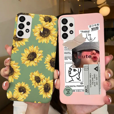 a woman holding up two iphone cases with sunflowers on them