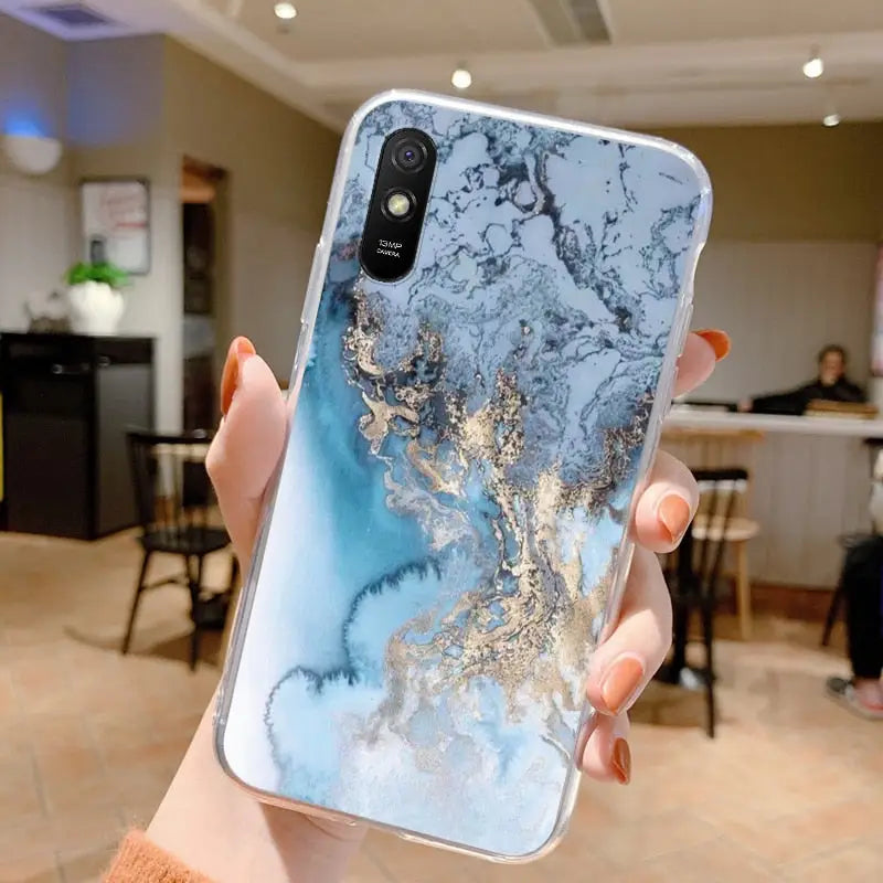 a woman holding up a phone case with a marble pattern