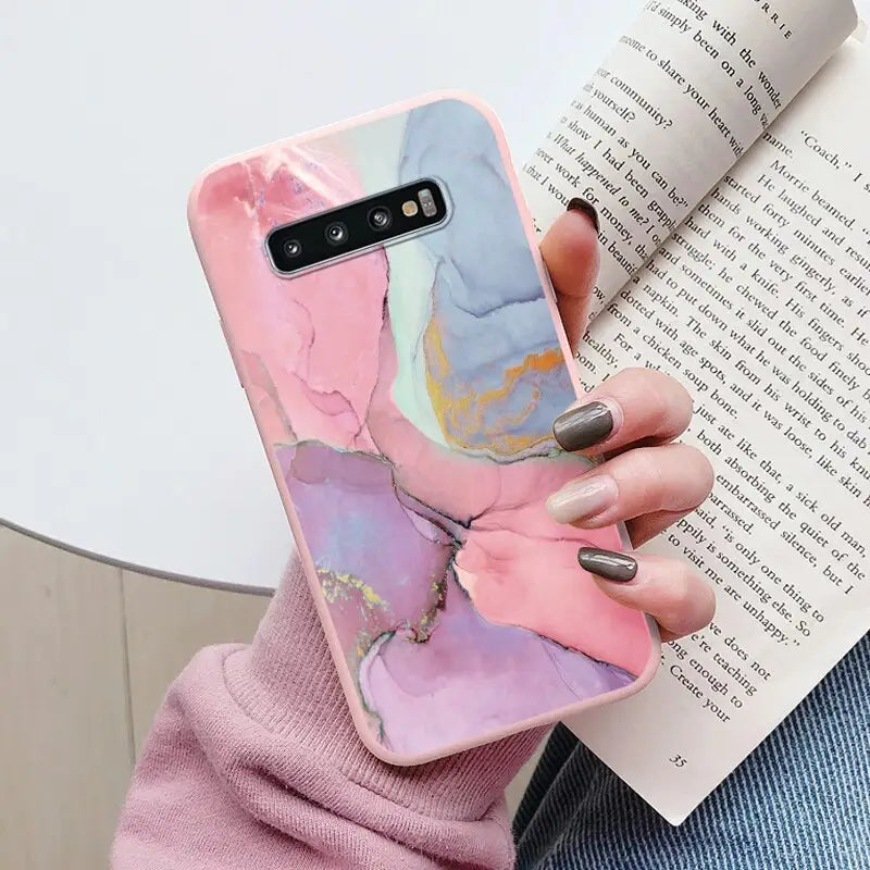 a woman holding a book and holding a phone case
