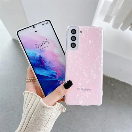 a woman holding a pink and blue phone case