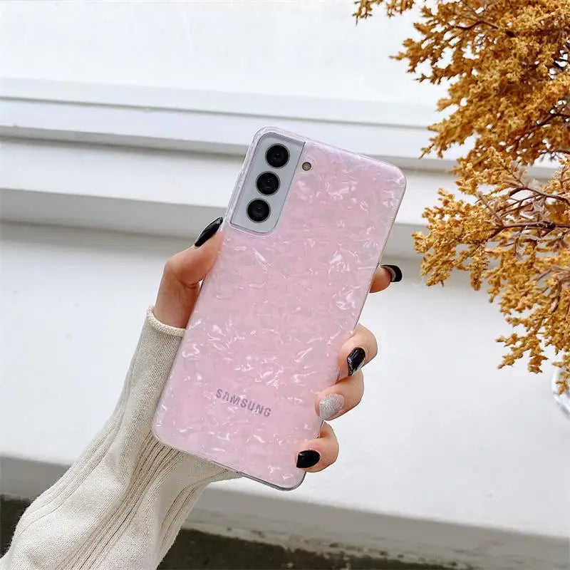 a woman holding a pink phone case