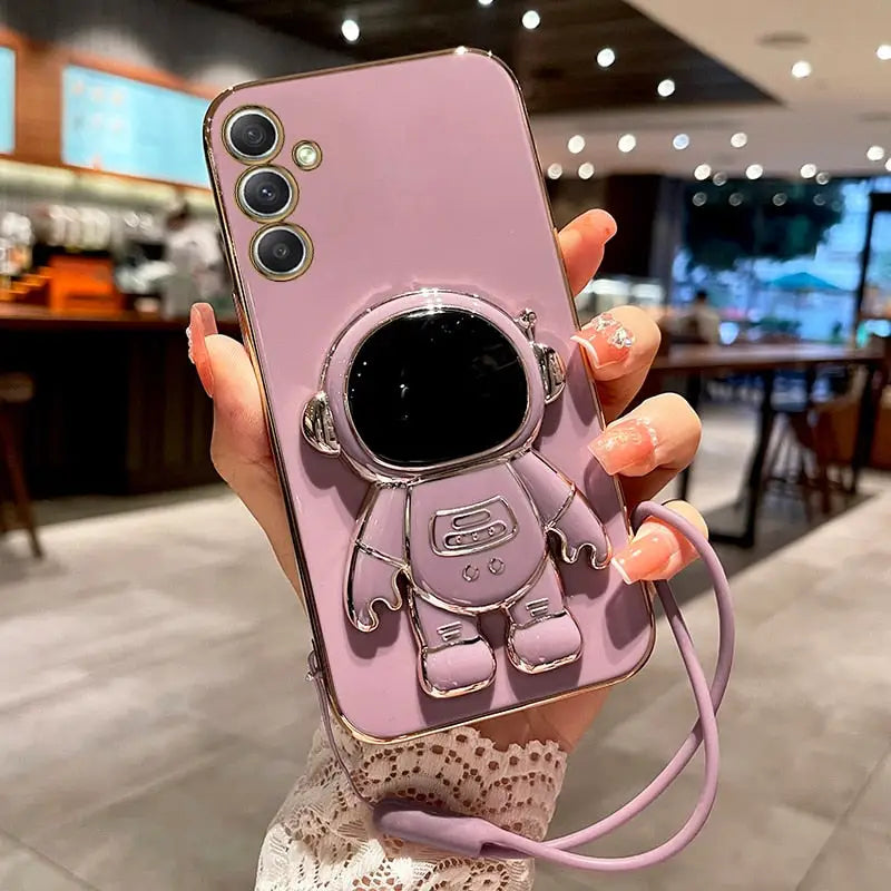 a woman holding a pink phone case with a camera attached to it