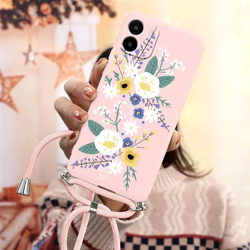 a woman holding a pink phone case with flowers on it