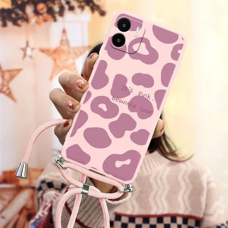 a woman holding a pink phone case with a pink leopard print