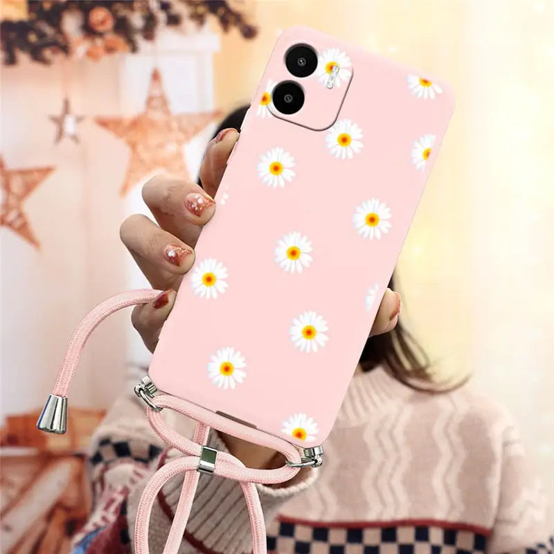 someone holding a pink phone case with daisies on it
