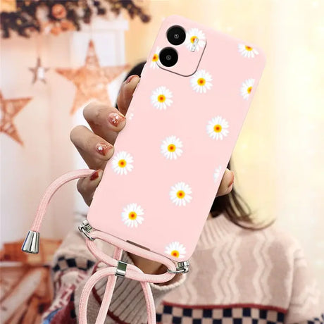 someone holding a pink phone case with daisies on it