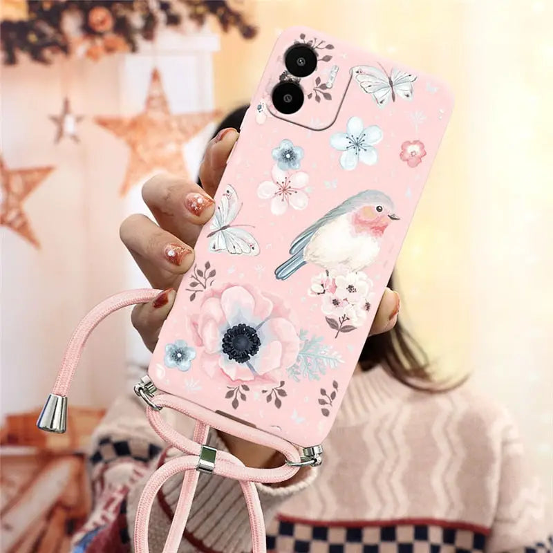 a woman holding a pink phone case with flowers and birds
