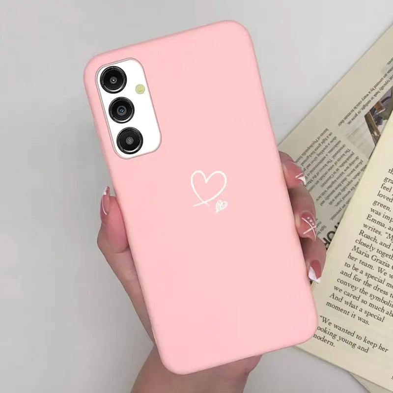 a woman holding a pink phone case with a heart on it