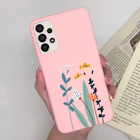 a woman holding a pink phone case with flowers on it
