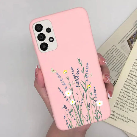 a woman holding a pink phone case with flowers on it
