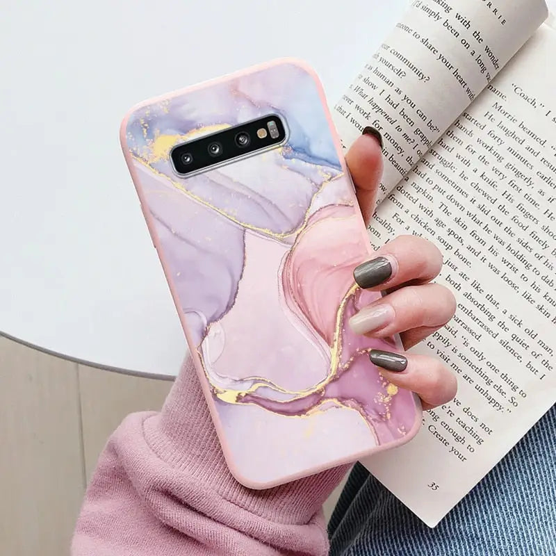 a woman holding a book and holding a phone case