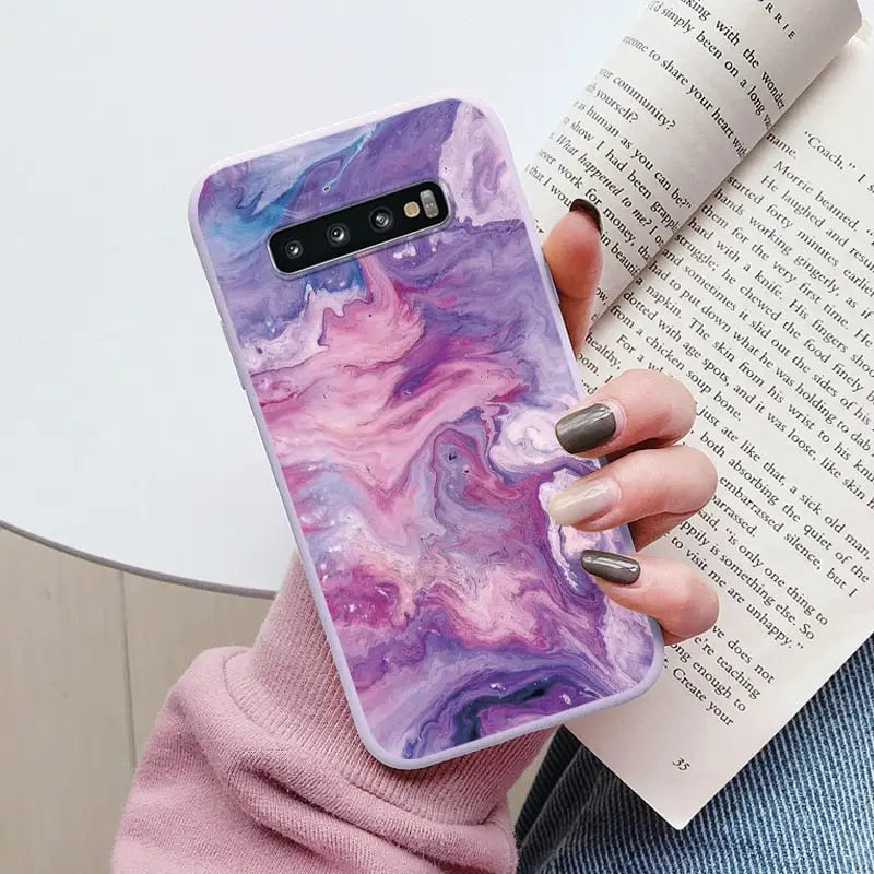 a woman holding a book and a phone case