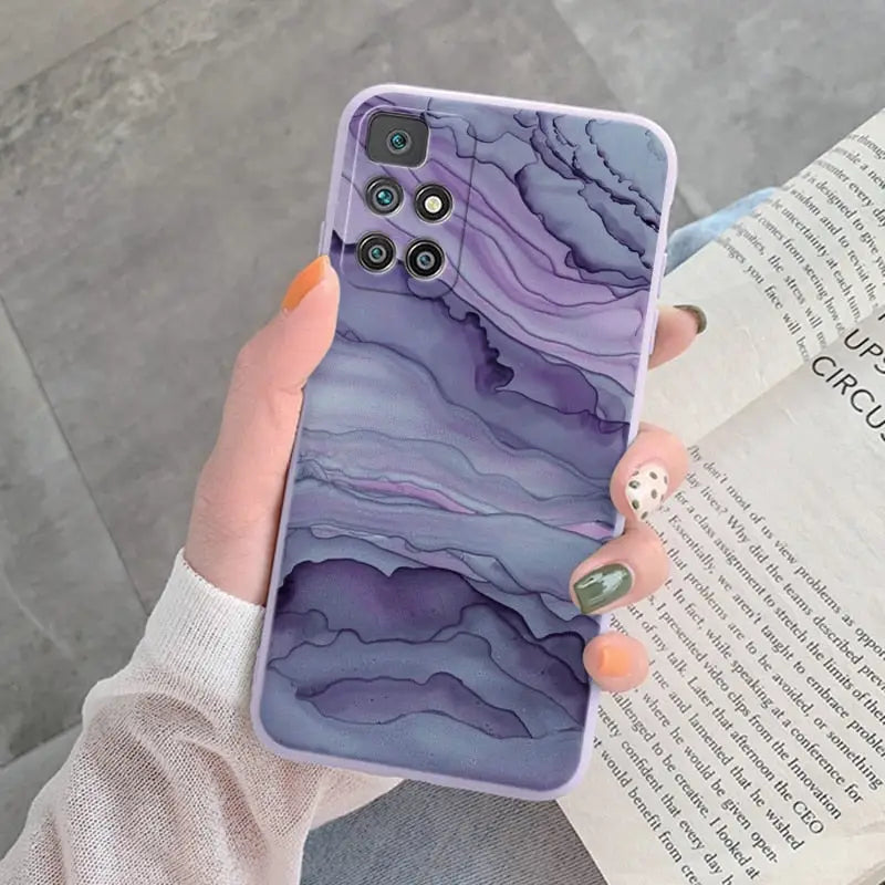 a woman holding a purple marble phone case