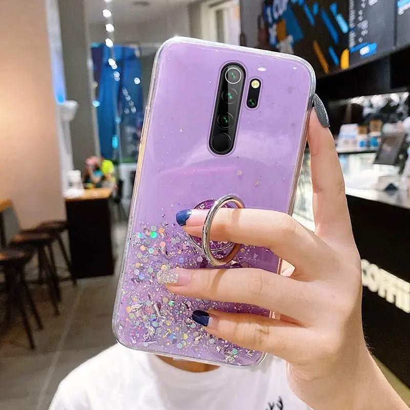 a woman holding a purple phone case with glitter