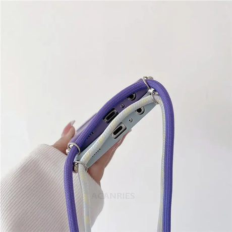 a woman holding a purple and white purse