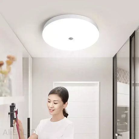 A woman is cleaning the kitchen with a vacuum