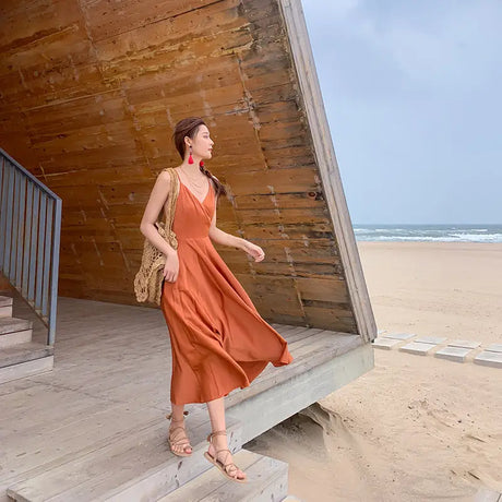 a woman in an orange dress standing on a wooden platform
