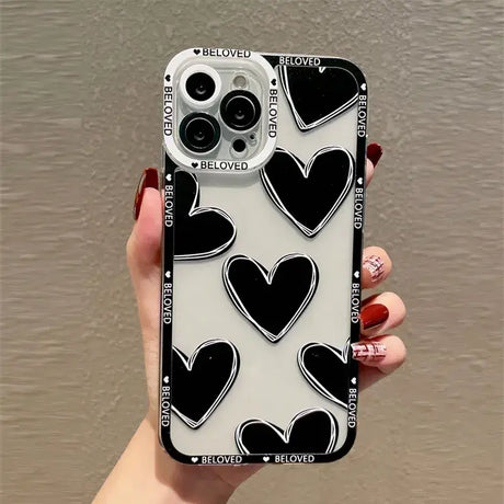 a woman holding a phone case with black and white hearts