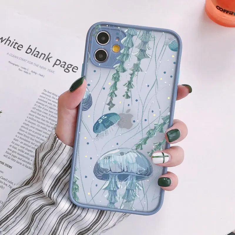A woman holding a phone case with a blue fish pattern