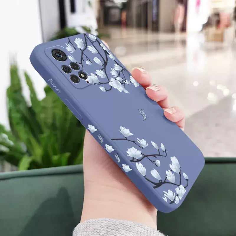 A woman holding a phone case with a blue flower design