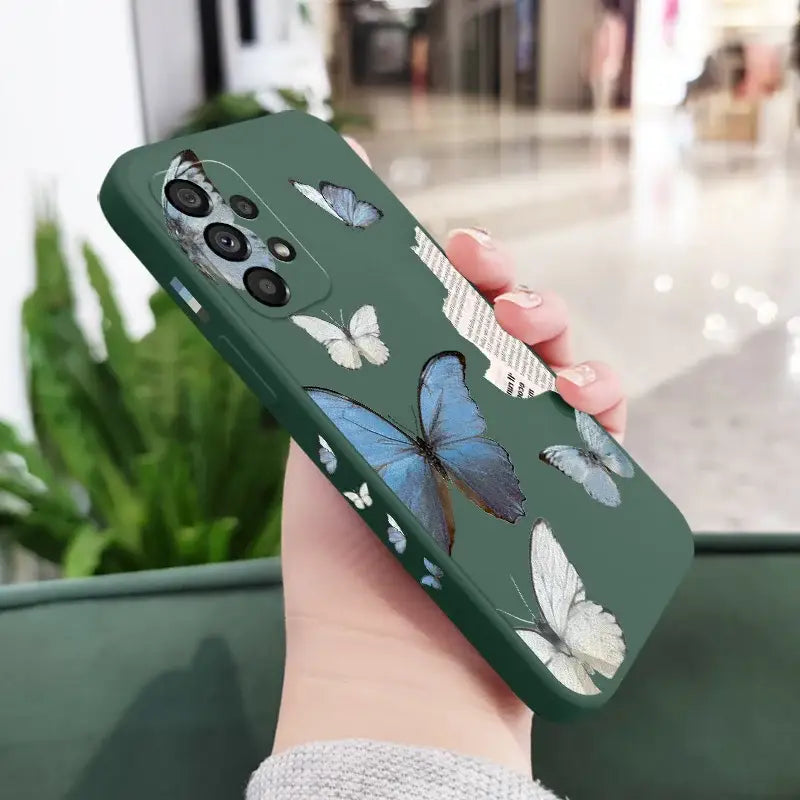 A woman holding a phone case with butterflies on it