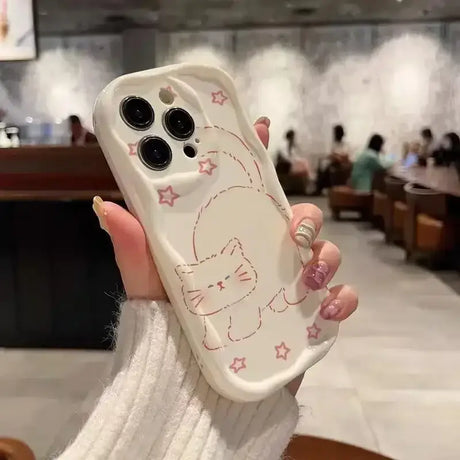 A woman holding a phone case with a cat design