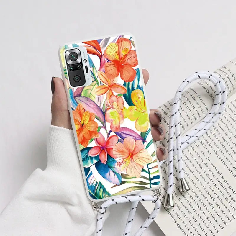 a woman holding a phone case with a colorful floral design