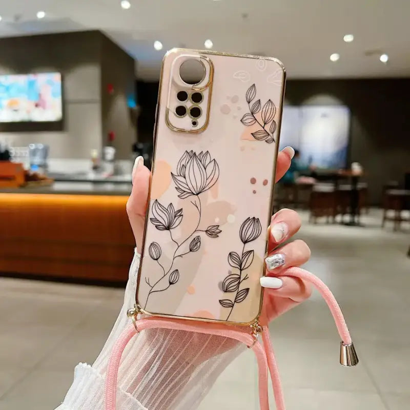 a woman holding a phone case with a flower design